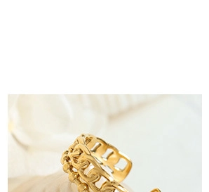 Close-up of gold chain-link open ring on white fabric with decorative seashells