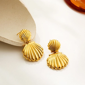 Macro shot of 18K gold double shell stud earrings showing intricate metallic texture