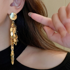 Detail of gold layered leaf sequin tassel earrings on model showing long fringe drop