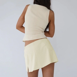 Rear view of a beige tank top and yellow mini skirt with heart-shaped back pockets