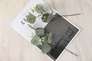 Flat lay of artificial eucalyptus branches with green leaves on marble texture desk