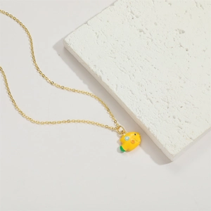 Detailed macro view of a golden necklace featuring a colorful fish enamel pendant