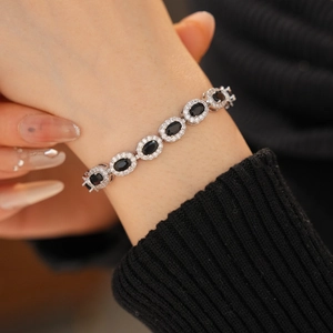 Macro shot of a silver adjustable bracelet with oval black stones and zircon borders