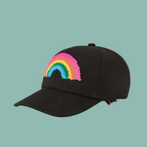 Detail of a black baseball cap featuring a vibrant 3D rainbow embroidery in textured chenille