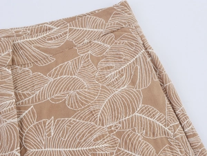 Macro shot of khaki cotton linen fabric with white leaf embroidery detail
