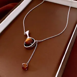 Collier en Y argenté avec perles œil-de-chat brunes sur fond de cuir marron