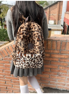 Dettaglio dello zaino in peluche leopardato con logo in pelle e robusto manico superiore