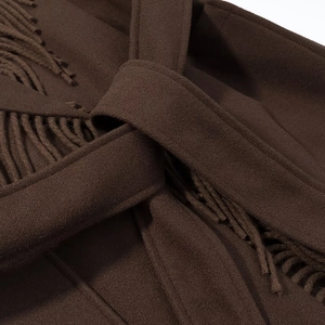 Détail du manteau en laine marron foncé avec bordures à franges et ceinture à nouer