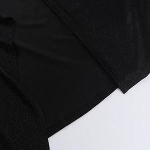 Detailed macro shot of black glitter fabric showing fine texture and hemline stitching