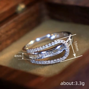 Luxe silver ring with micro-paved cubic zirconia layers in a premium jewelry box
