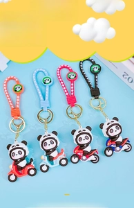 Detail of creative 3D panda motorcycle keychains with woven lanyards and gold metal rings