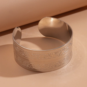 Detail of vintage wide metal cuff with intricate butterfly and floral embossed patterns