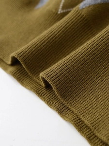 Detail of olive green argyle knit sweater with white grey pattern and ribbed cuffs