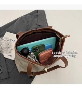 Top-down view of spacious tote bag interior holding a tablet, phone, wallet, and umbrella