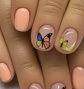 Detailed view of press-on nails featuring colorful artistic butterfly patterns on nude base
