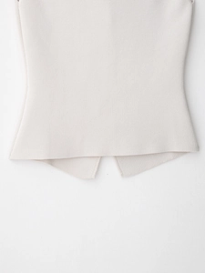 Detailed macro view of cream knitted vest top featuring unique inverted V-cut hemline
