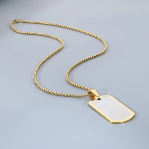 Detailed view of a gold military tag necklace with a white mother of pearl inlay detail