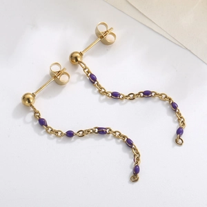 Detail of gold chain drop earring with purple resin beads on white background