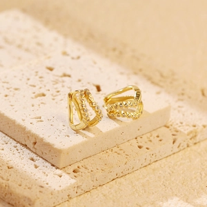 Detail of S925 hallmark on gold double-layer hoop earrings with diamond accents
