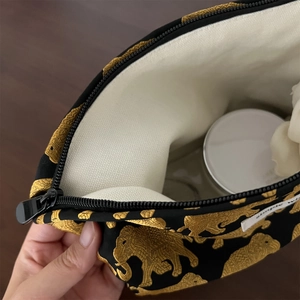 Detail view of jacquard elephant pouch interior showing storage space and cream lining
