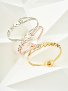 Detailed view of wheat leaf bangles in gold, silver and rose gold with zircon stones