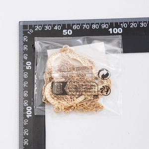 Detailed measurement of gold heart pendant body chain on ruler in packaging