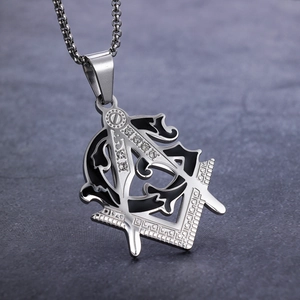 Macro shot of silver Freemason pendant with black enamel inlay and white crystals