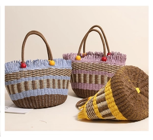 Detail of bohemian straw buckets with frayed edges and wooden bead handles in various colors