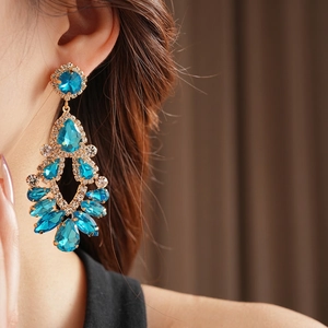 Elegant gold-tone chandelier earrings with blue drop stones and crystal tassel detail