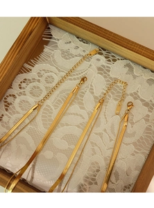 Double-layered gold snake chain necklace with lobster clasp on white lace and wood frame