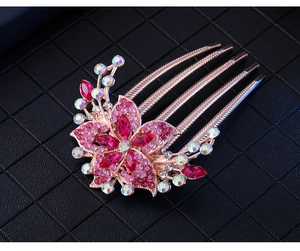 Detailed close-up of rose gold five-tooth flower hair comb with pink rhinestones