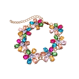Vintage gold bracelet featuring colorful gemstone flower charms on white background