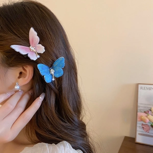 Détail de pinces à cheveux papillon avec strass étincelants et perles élégantes