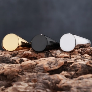 Polished stainless steel signet rings in gold, black and silver on rustic wood bark background