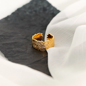 Macro shot of 18k gold leaf pattern texture on adjustable stainless steel ring