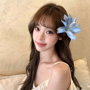 Elegant large blue fabric flower hair clip shown on model for a minimalist hair accessory look