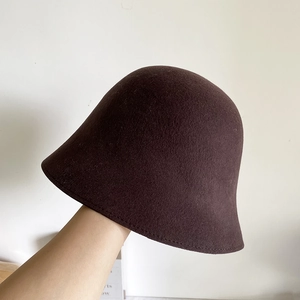 Détail du tissu en laine d'un chapeau bob marron foncé montrant la texture et les coutures