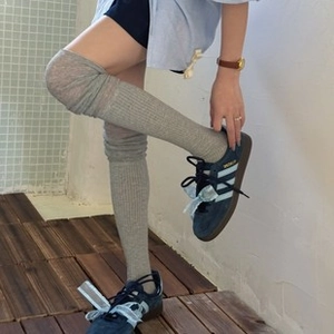Detail of grey ruffled cotton socks with vertical ribbed texture on a model
