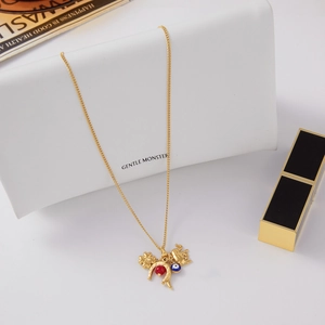 Detail view of gold titanium necklace with clover, elephant, horseshoe, and evil eye charms