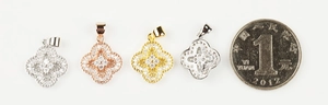 Macro shot of micro-paved four-leaf clover charms in gold, silver and rose gold tones