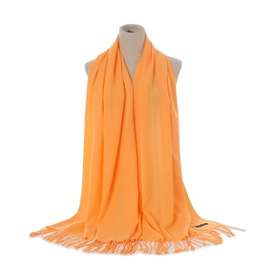 Close-up detail of soft bright orange faux cashmere scarf with twisted tassel fringe edges