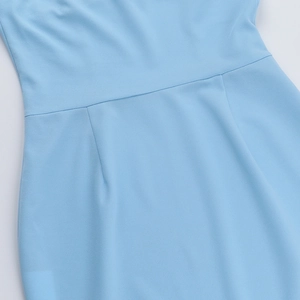 Close-up of the light blue dress showing detailed waist stitching and pleated fabric texture