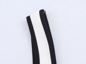 Close-up of black and white striped shoulder strap detailing with high-quality stitching