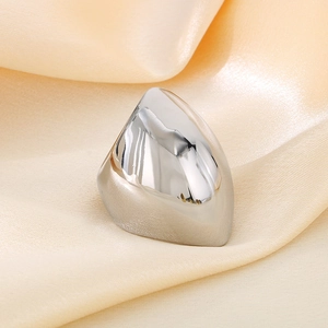 Close-up of a silver irregular polished stainless steel ring on beige silk fabric