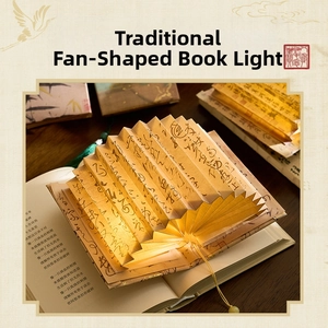 Detail of fan-shaped book lamp with warm yellow light and Chinese calligraphy patterns