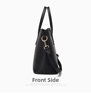 Detail view of the black crocodile pattern tote bag featuring golden metal buckles
