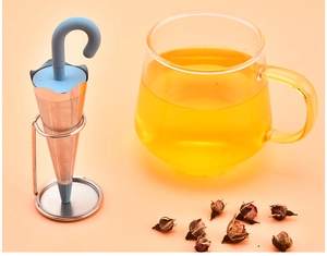 Detailed view of blue umbrella tea infuser with stainless steel base on orange background