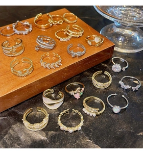 Detailed close-up of a diverse collection of sparkling zircon open rings in gold and silver