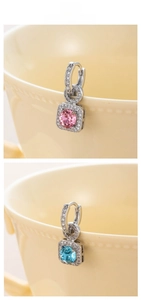 Macro detail of luxury silver earrings with pink and blue square zircon crystals