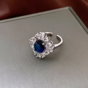 Elegant French vintage ring with blue oval gemstone and sparkling zircon halo design